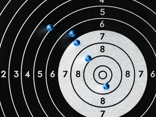 Balls or bullets for pneumatic shooting lie on a paper target. Dark inverted illustration. Top-down