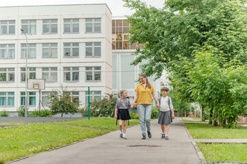 two little happy girl with mom go to school education concept. High quality photo