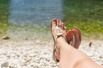 beautiful legs on a rocky beach. woman feet on front of sea rocky beach. Rest, vacation, love concept
