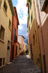 Fototapeta na wymiar Calle angosta de pueblo estilo medieval retro vintage con nubes y edificios coloridos en tonos pastel