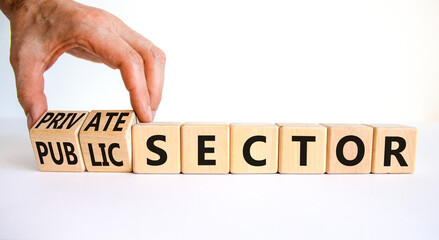 Private or public sector symbol. Businessman turns cubes and changes words 'public sector' to...