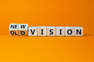 New or old vision symbol. Turned wooden cubes, changed words 'old vision' to 'new vision'. Beautiful orange table, orange background, copy space. Business, old or new vision concept.