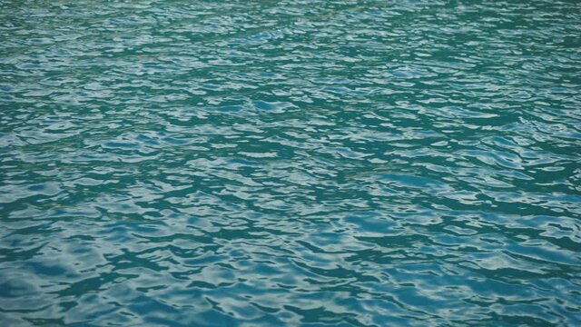 Rippled sea surface reflecting sky. Full frame abstract blue water background. Calming scene in nature. 