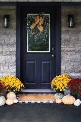 Rustic Front Porch Decorated for Thanksgiving Day Holiday with Mums and Pumpkins