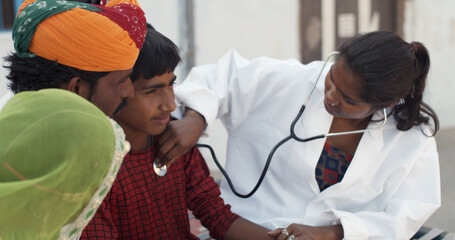 Closeup shot of a South Asian female doctor checking up on a male child