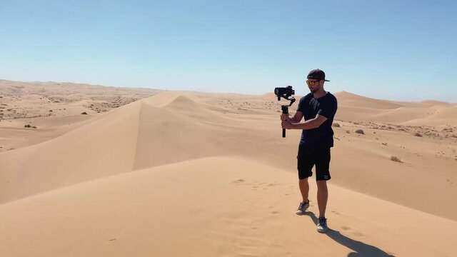 Filmmaker filming in the desert with cinema camera and gimbal