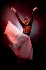 ballerina with a white dress and black top posing on red smoke background © Nikola Spasenoski