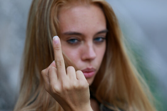 Rude vindictive young woman giving the middle finger