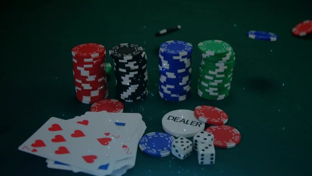 Animation of confetti and poker chips falling onto stacks, dice and playing cards on gambling table
