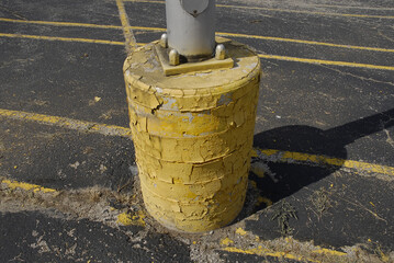Closeup shot of the yellow concrete pier of a parking lot light pole in Missouri