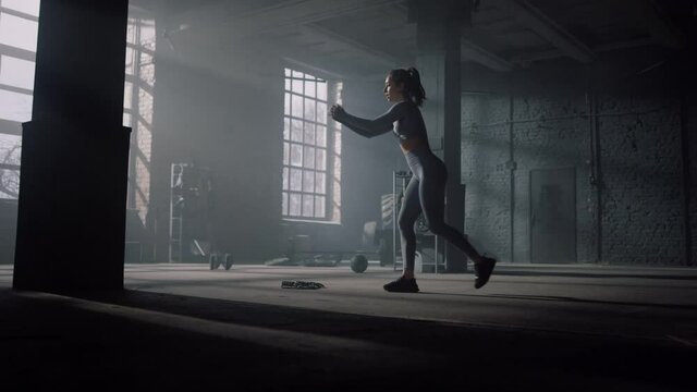 Bodybuilder practicing booty workout in gym. Girl doing squats with lunges