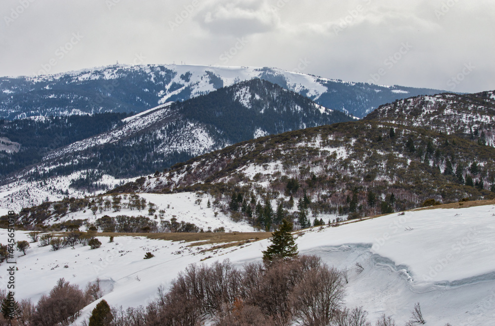 Poster scenic view of mountains and fields enveloped in snow on a cloudy sky background
