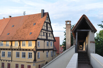 Beautiful building with a tile roof next to a small long tunnel on the roof of another building