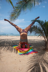 head girl meditates doing yoga by spreading her legs in the air near the beach