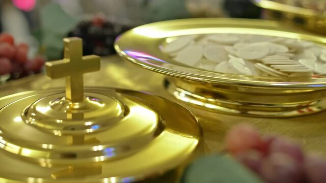 Christian Communion, top view of a golden cross, sacramental bread and wine on a box