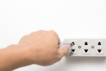 Hands holding plugged in power socket on white background