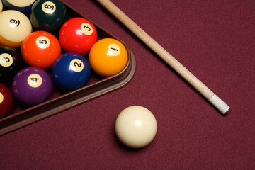 billiard pool table with cue stick, triangle, and balls close up