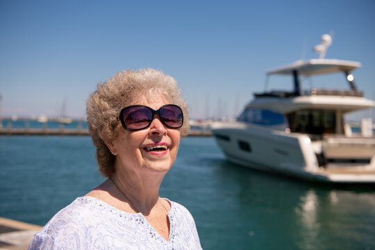 A beautiful senior woman enjoys the day taking a walk by the lake.