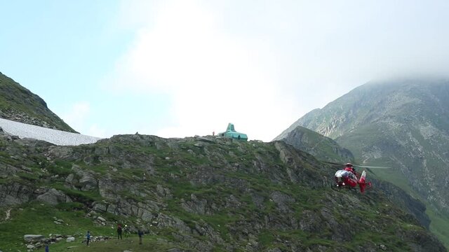 FAGARAS MOUNTAINS, ROMANIA - Jul 16, 2020: A team of mountain rescuers and medical crew by helicopter in the Fagaras mountains to rescue a tourist who suffered a knee injury in HD