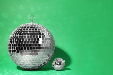 Shiny disco balls on green background. Space for text