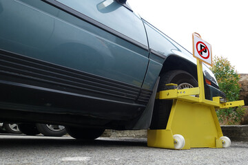 Front car wheel clamped for illegal parking at the roadside, a violation car park.  