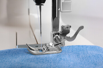 Sewing machine with light blue cloth, closeup