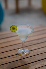 A cocktail glass decorated with lemons on the beach. selective focus (close up view)