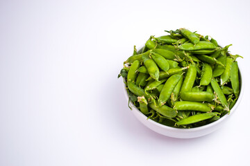 White cup with green peas in pods, on a white background, advertising a healthy lifestyle, daily rate of protein and fiber.