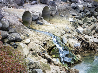 View of concrete storm water pipe discharging water