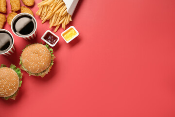 Obraz na płótnie Canvas Flat lay composition with delicious fast food menu on red background. Space for text