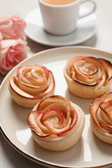 Obraz na płótnie Canvas Freshly baked apple roses served on light table. Beautiful dessert