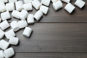Delicious puffy marshmallows on wooden table, flat lay. Space for text