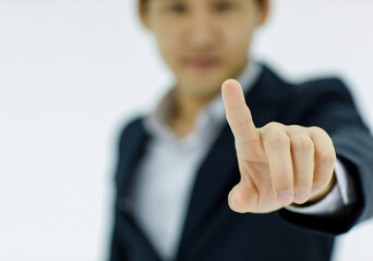 Isolated studio close up shot hand of Asian successful professional businessman wears black formal suit stand in blurred white background with index finger pointing touching choosing blank space