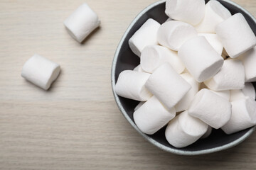 Delicious puffy marshmallows on wooden table, flat lay