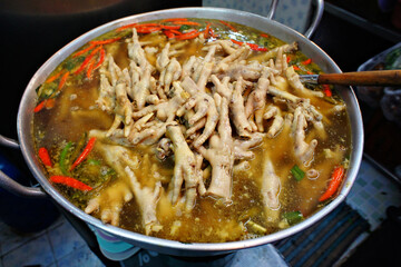 High angle view chicken feet in hot and spicy soup. Bangkok street food.