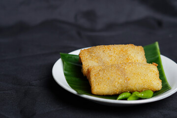 Fried spring rolls isolated on black background. This typical Semarang food which is sometimes spelled as “lun pia” is a kind of traditional Chinese-Javanese fusion of snacks. Focus blur. Snack mockup