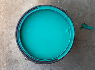 Bucket of Teal Paint on Cement Floor