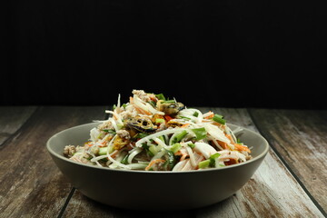 Traditional spicy mixed seafood salad serving on the plate. Famous appetizer menu in Asia restaurant. 