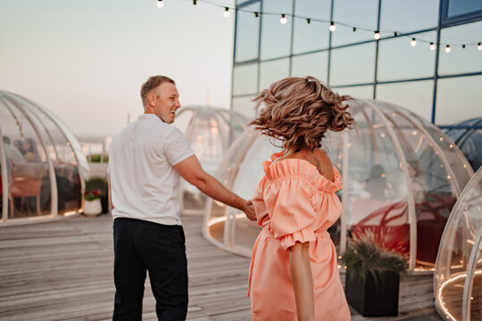 a man and a woman in love walk to a rooftop cafe on a date.