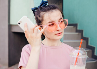 Playful cool funky hipster young girl with mobile phone app while walking on city street – Street...