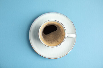 Cup of hot aromatic espresso on light blue background, top view