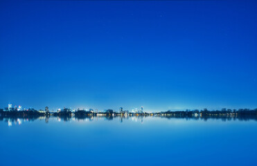 Rotterdam in the Netherlands at night, blue sky and lake, distant view