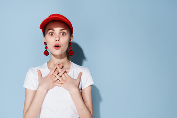 fashionable woman in red cap earrings posing Glamor blue background