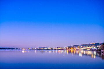 Fototapeta na wymiar Night view of Lake Fusaro in Naples, Italy, with blue sky and water