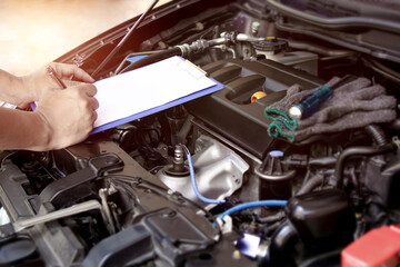 On site concept : Employees technician checking list on the paper note for maintenance and service of broken car