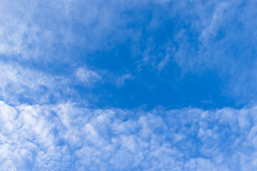 A blue sky with white clouds spread across the sky.