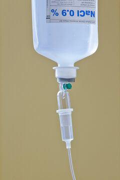 Close-up image of the 0.9% Normal saline solution(NSS) or sodium chloride(NaCl) with infusion bottle drip for patient in clinical care unit of hospital. Selective focus. PENANG, MALAYSIA - 7 JAN 2016.