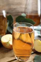 Glass of delicious apple cider on wooden table