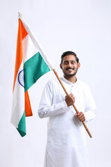 Young indian man holding indian national flag in hand over white background