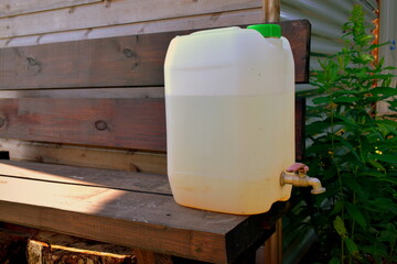 plastic canister with a tap on a bench in the garden